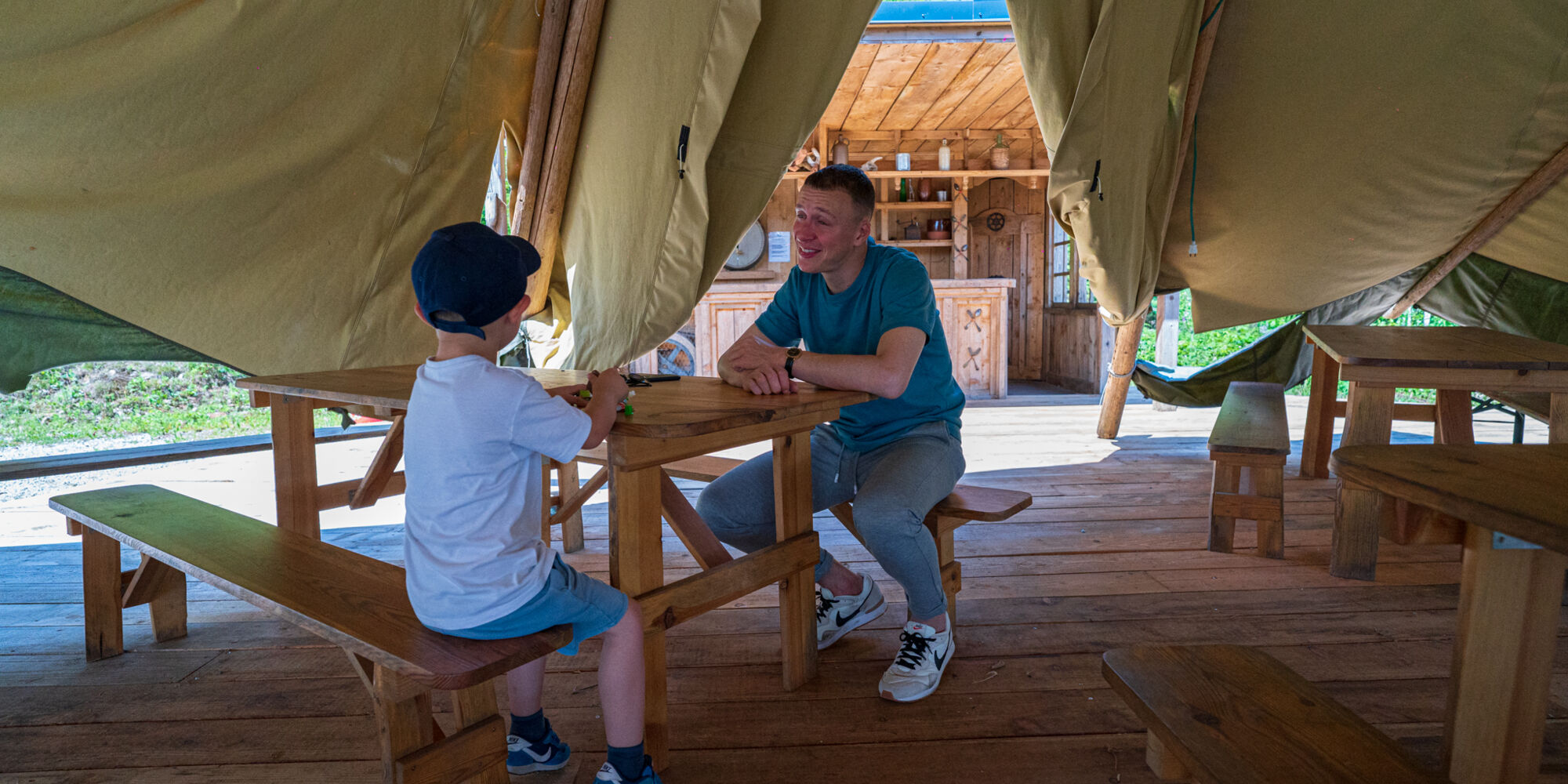 Un parent et son enfant sous la tente d'un des espaces de pique-nique